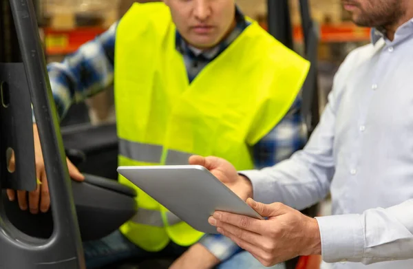 Männer mit Tablet-PC und Gabelstapler im Lager — Stockfoto