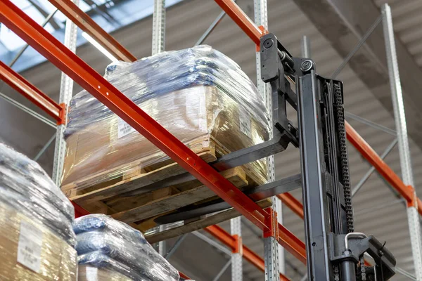 Forklift loader loading cargo to warehouse shelves — Stock Photo, Image
