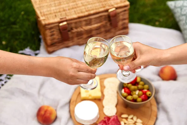 Zblízka ruce cinkání sklenice na víno na piknik — Stock fotografie