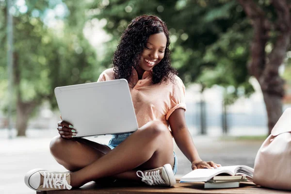 Afrikanska student flicka med bärbar dator och böcker i staden — Stockfoto