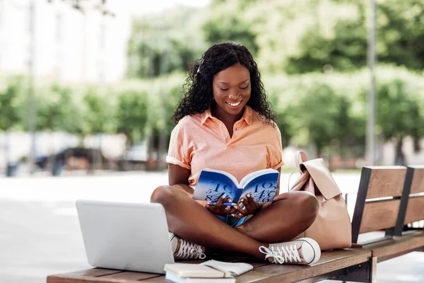 Afrikanska student flicka läsa bok i staden — Stockfoto