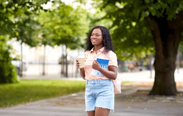 Африканская студентка с кофе и книгой в городе — стоковое фото