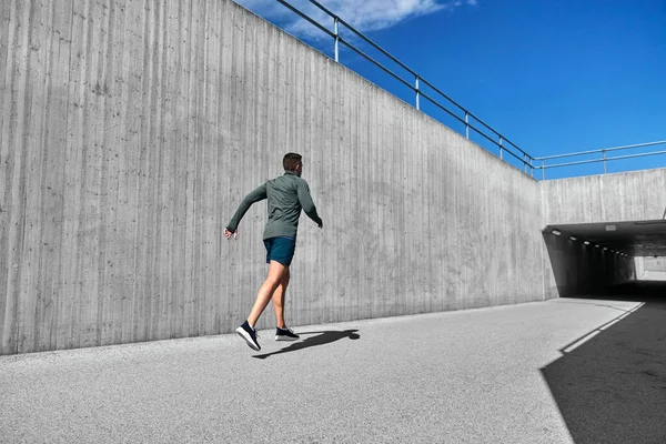 Young man running out of tunnel — Stock Photo, Image