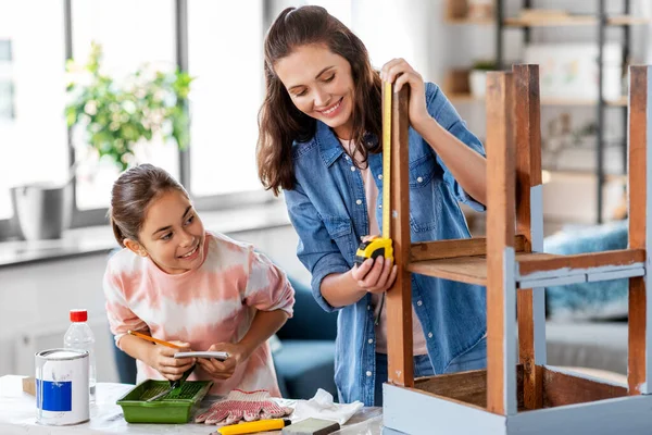 Madre e hija con regla midiendo mesa vieja — Foto de Stock