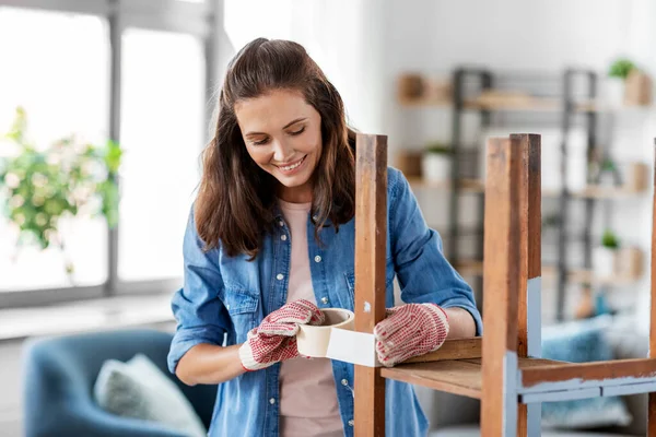 Woman sticking masking tape to table for repaint — Stock Photo, Image