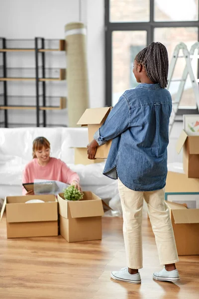 Femmes déballer des boîtes et déménager dans une nouvelle maison — Photo