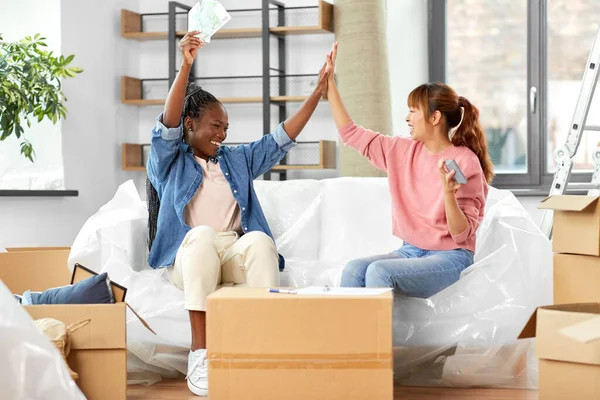 happy women moving to new home and counting money