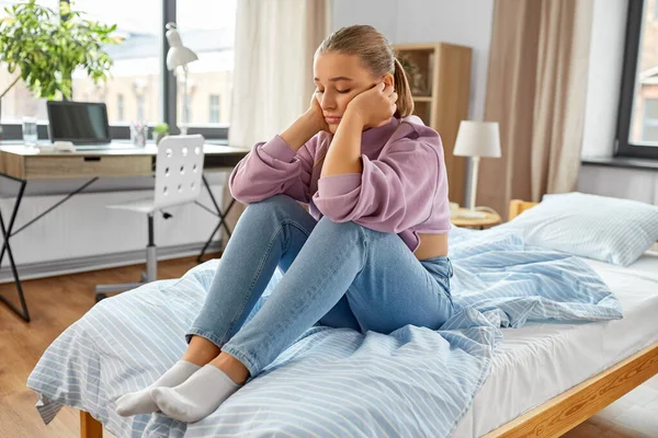 Triste fille assis sur le lit à la maison — Photo