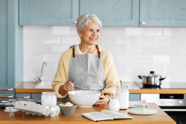 Lycklig kvinna matlagning mat på köket hemma — Stockfoto
