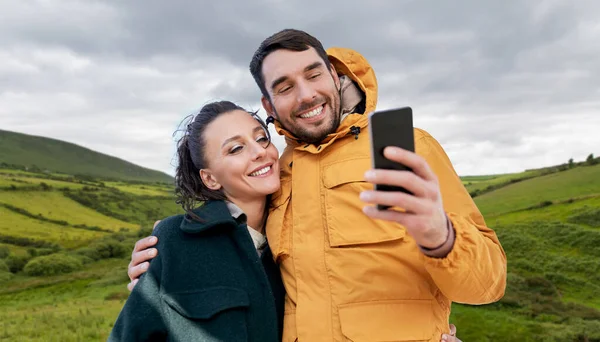 Para biorąc selfie ze smartfonem w Irlandii — Zdjęcie stockowe