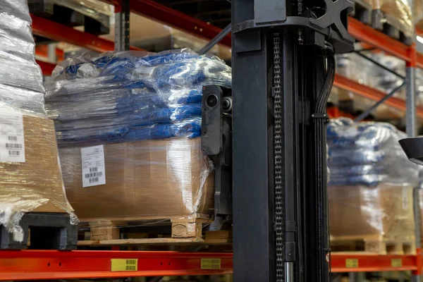 Forklift loader loading cargo to warehouse shelves — Stock Photo, Image
