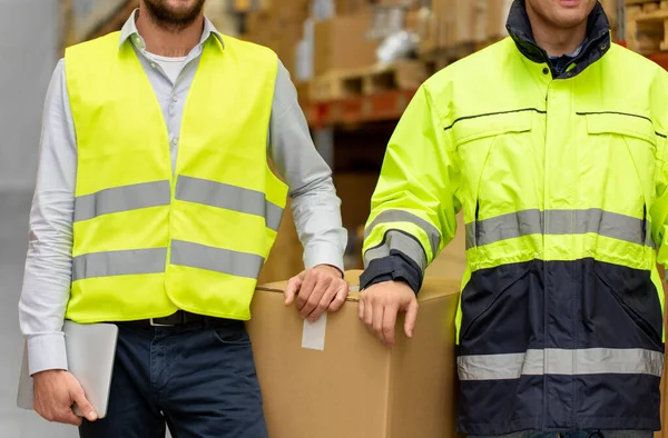 Hommes en uniforme avec boîtes en entrepôt — Photo