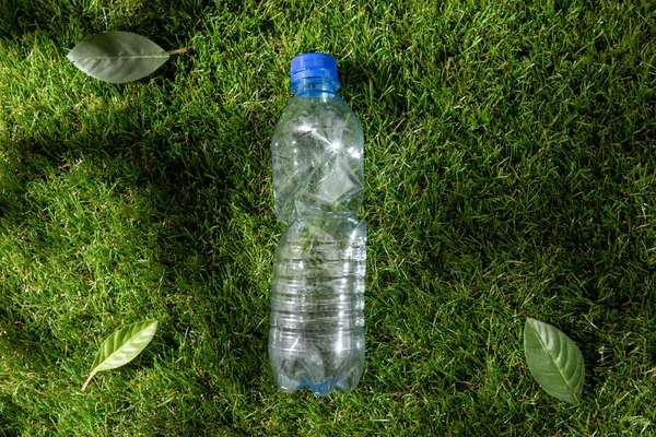 Nahaufnahme einer leeren gebrauchten Plastikflasche auf Gras — Stockfoto