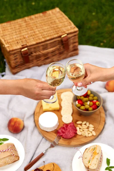 Zblízka ruce cinkání sklenice na víno na piknik — Stock fotografie
