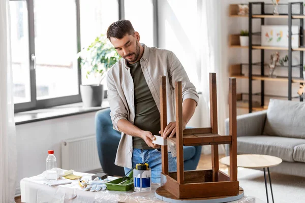Homem colando fita adesiva para a mesa para repintura — Fotografia de Stock