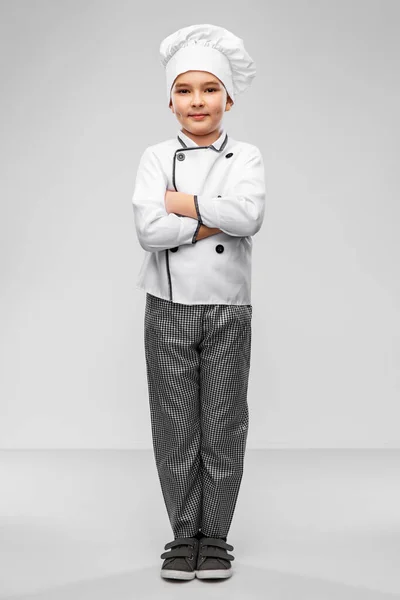 Улыбающийся мальчик в костюме шеф-повара и куртке — стоковое фото