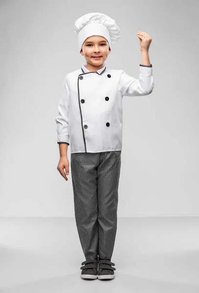 Glimlachende kleine jongen in koks toque en jas — Stockfoto