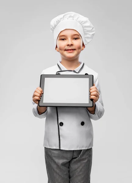 Garotinho sorridente em chefs toque com tablet pc — Fotografia de Stock