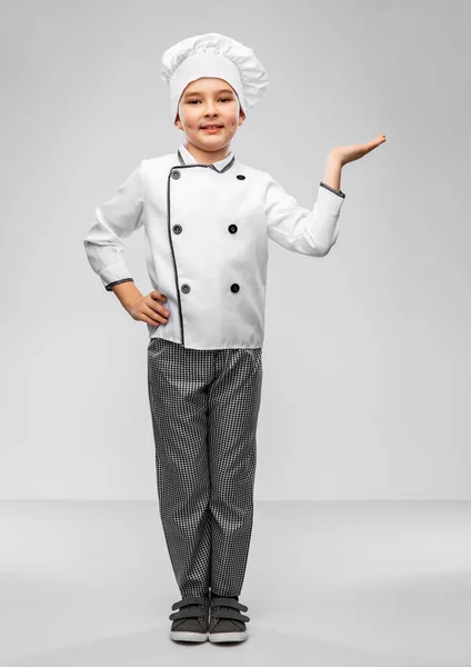 Mosolygós fiú szakácsok toque kezében valamit Stock Kép