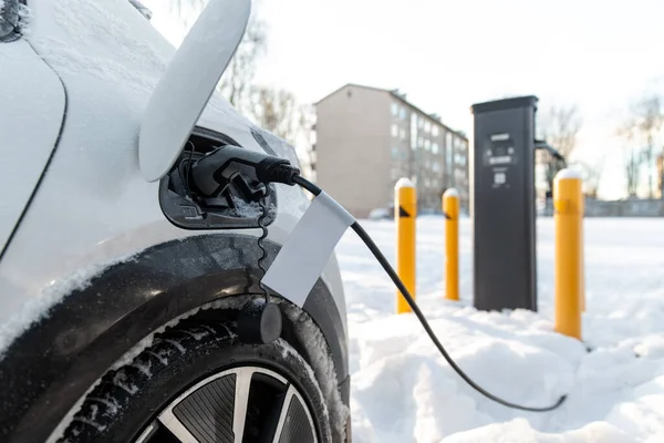 Kışın elektrikli araba şarj oluyor. — Stok fotoğraf