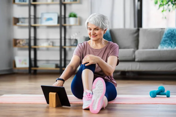 Ευτυχισμένη γυναίκα με tablet pc άσκηση στο σπίτι — Φωτογραφία Αρχείου