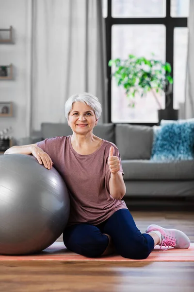 Χαμογελαστή ηλικιωμένη γυναίκα με μπάλα γυμναστικής στο σπίτι — Φωτογραφία Αρχείου