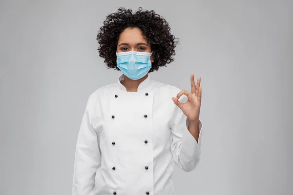 Kvinnlig kock i medicinsk mask visar ok gest — Stockfoto