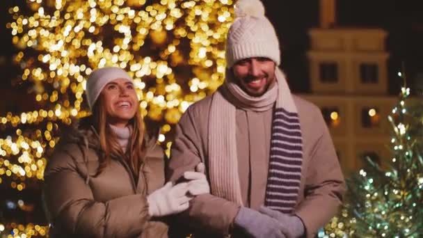 Lyckligt par promenader i staden över jul ljus — Stockvideo