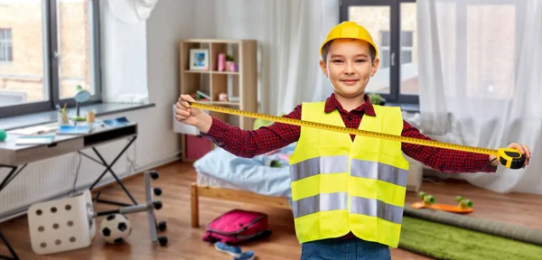 Chlapec ve stavební helmě a vestě s pravítkem — Stock fotografie