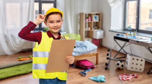 Little boy in construction helmet with clipboard — Stock Photo, Image