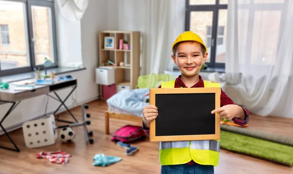 Kleiner Junge im Schutzhelm mit Kreidetafel — Stockfoto