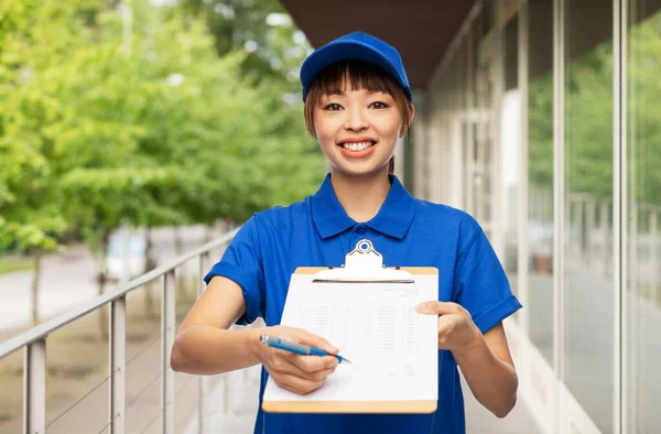 Happy delivery woman with clipboard and pen — Stock Photo, Image