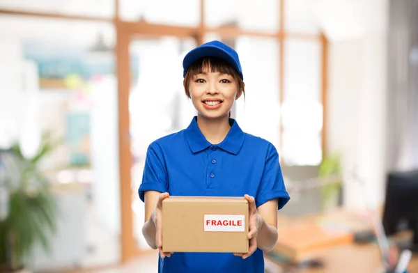 Happy delivery woman holding parcel box at office — Stock Photo, Image