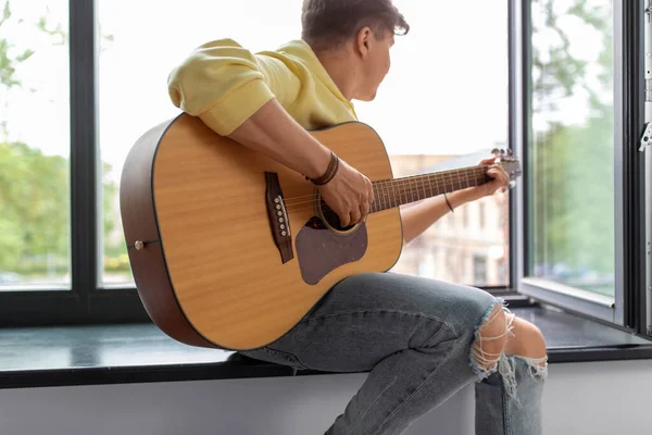 Primer plano del hombre tocando la guitarra sentado en el alféizar — Foto de Stock