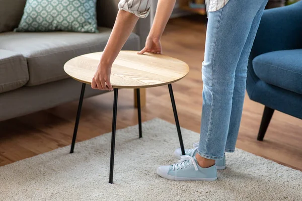 Femme plaçant la table basse à côté du canapé à la maison — Photo