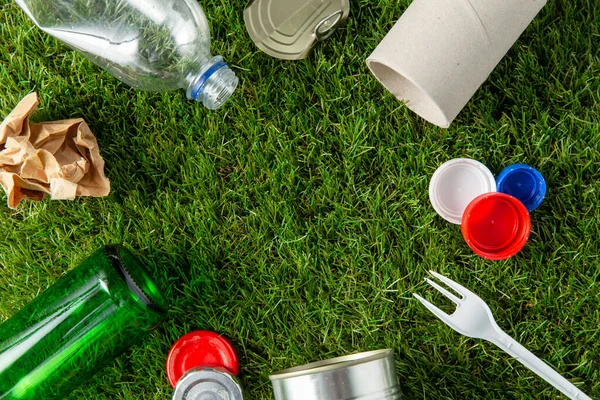 Close up of different household waste on grass — Stock Photo, Image