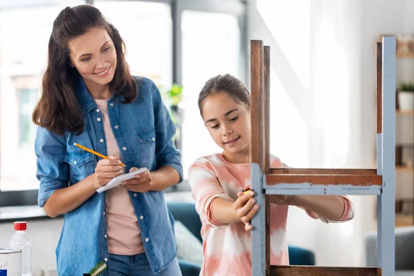 Mor och dotter med linjal som mäter gammalt bord — Stockfoto