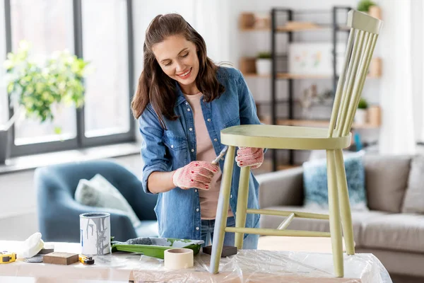 Mujer pintando silla vieja en color gris en casa —  Fotos de Stock