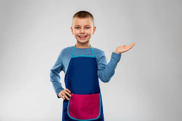 Little boy in apron holding something on hand — Stock Photo, Image