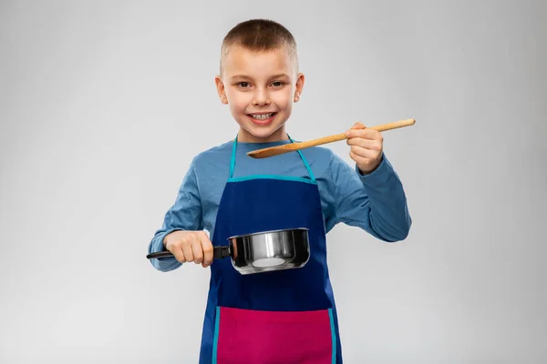 Маленький мальчик в фартуке с кастрюлей приготовления пищи — стоковое фото