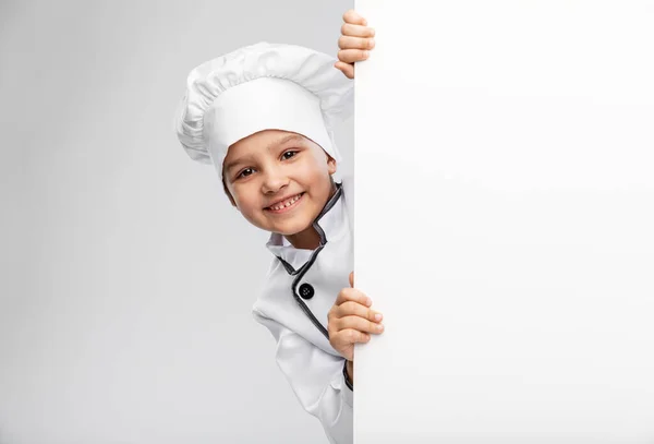 Menina feliz em chefs toque com placa branca — Fotografia de Stock