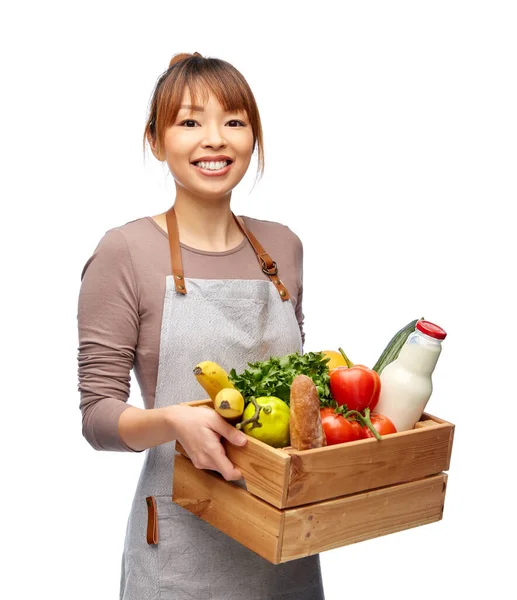 Feliz cocinera sonriente con comida en caja de madera —  Fotos de Stock