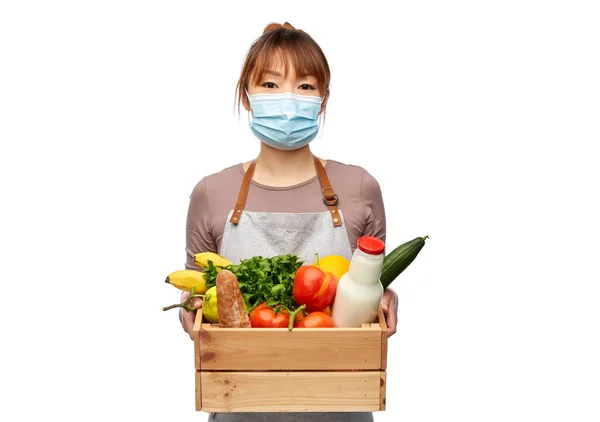 Chef mujer en máscara con comida en caja de madera —  Fotos de Stock