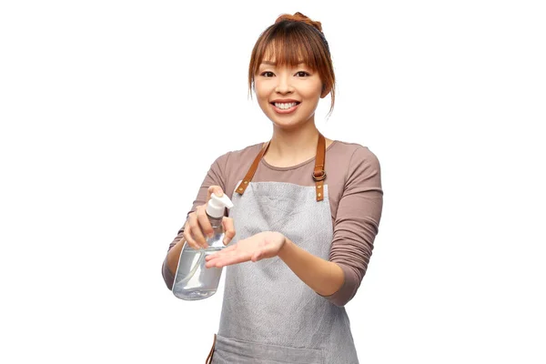 Mujer feliz en delantal con desinfectante de manos o jabón —  Fotos de Stock