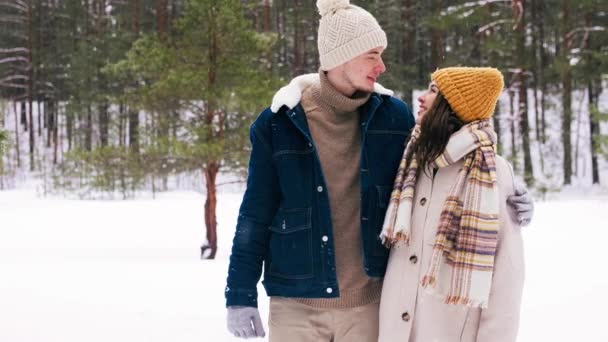 Пара смотрит друг на друга в зимнем лесном парке — стоковое видео