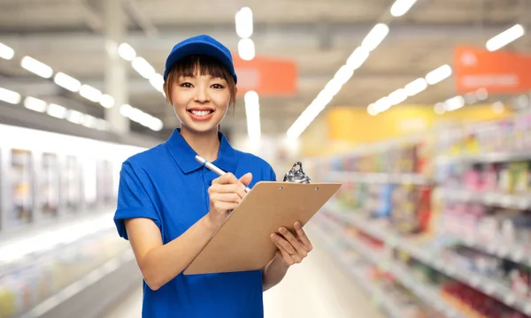 Glückliche Zustellerin mit Klemmbrett und Stift — Stockfoto