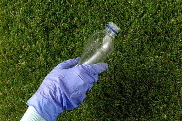 Kéz a kézben szedés műanyag palack fű — Stock Fotó