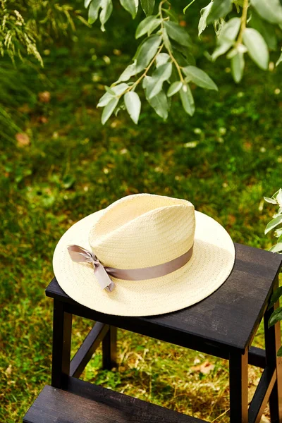 Primo piano di cappello di paglia su sgabello a giardino estivo — Foto Stock