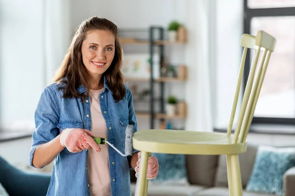 Woman painting old chair in grey color at home — Stock Photo, Image