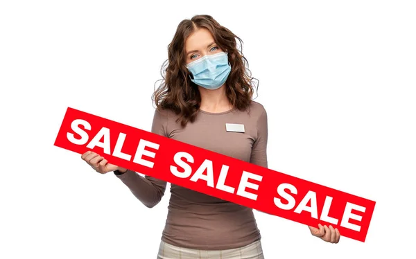 Vendedora con máscara sosteniendo banner rojo de la venta — Foto de Stock
